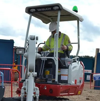 Operator using a Takeuchi TB216 compact excavator