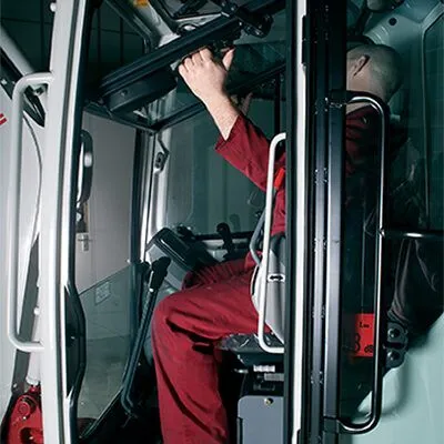 Operator entering the cab of a Takeuchi TB216 excavator