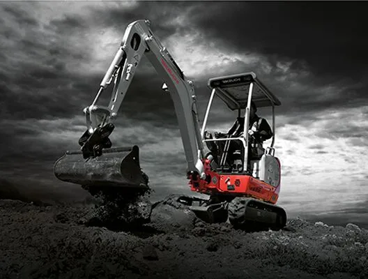Takeuchi TB216 compact excavator digging in dramatic site lighting