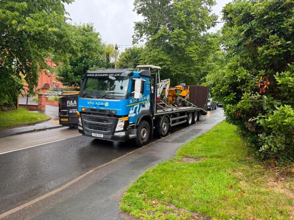 Sims Plant Hire lorry travelling along a leafy country lane
