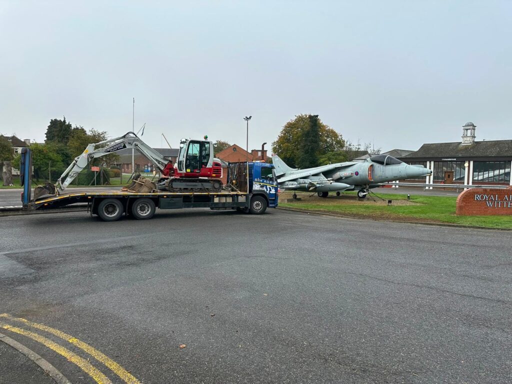 Compact excavator secured on a Sims low-loader for the UK construction plant hire equipment fleet