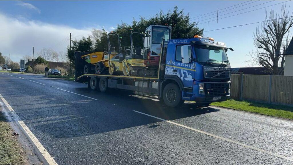 Sims lorry transporting groundworks machinery in the UK
