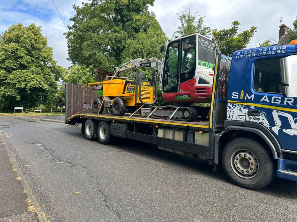 Sims lorry transporting construction equipment along a public road for the plant hire gallery in the UK