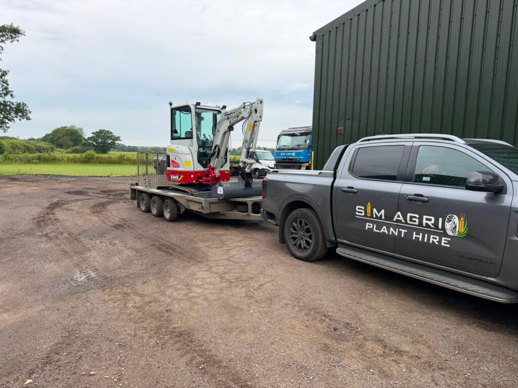 Pickup towing a Takeuchi excavator for plant hire in Oxford