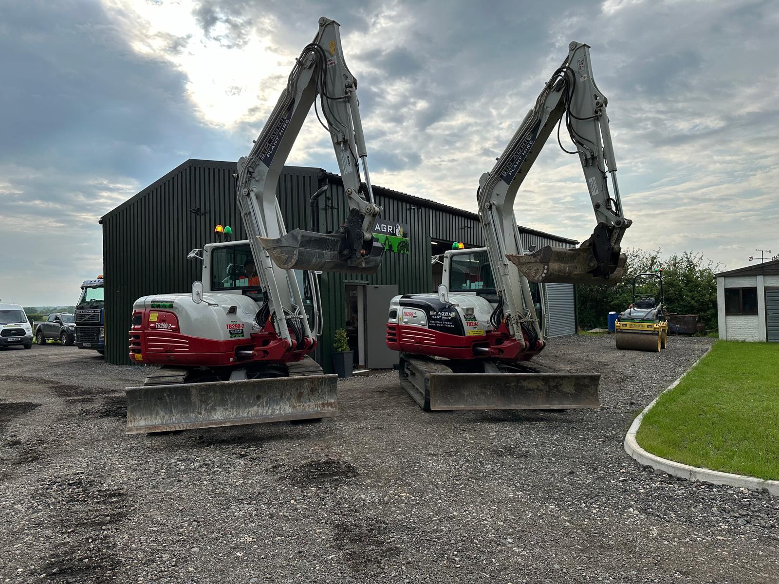 Two compact excavators parked outside the Sims workshop