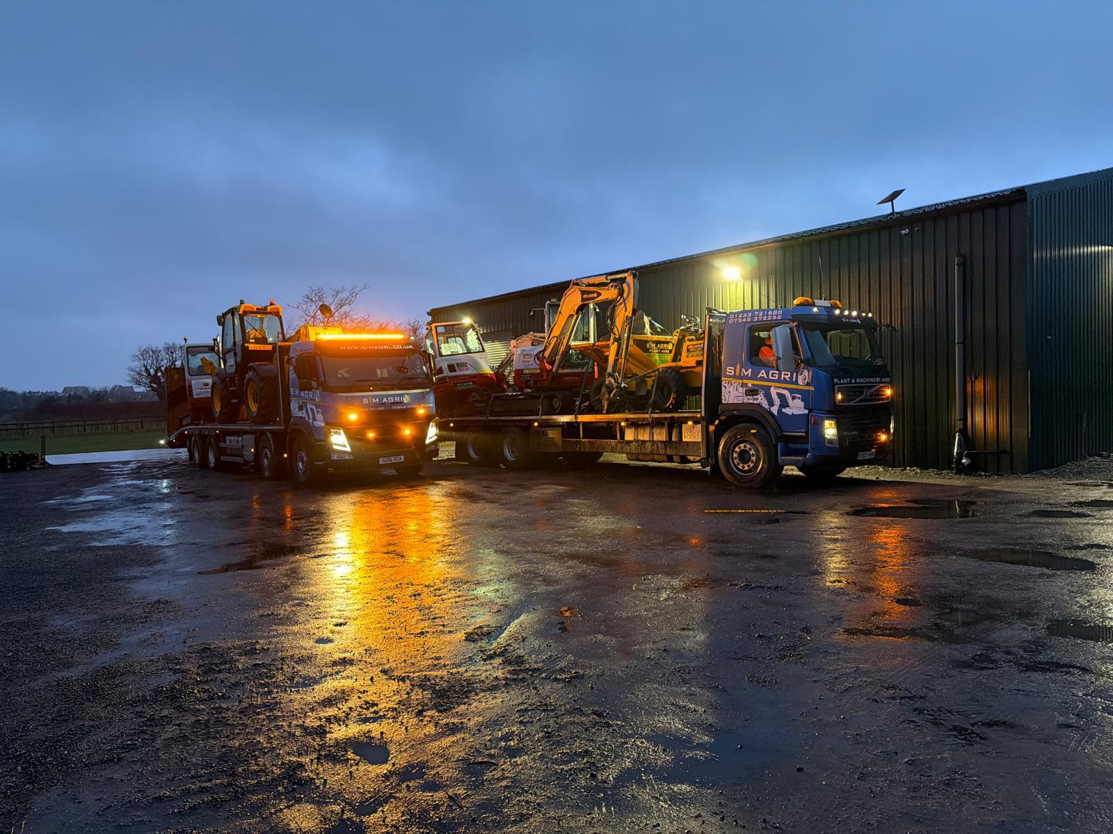 Sims plant transport fleet at the depot at night for domestic plant hire