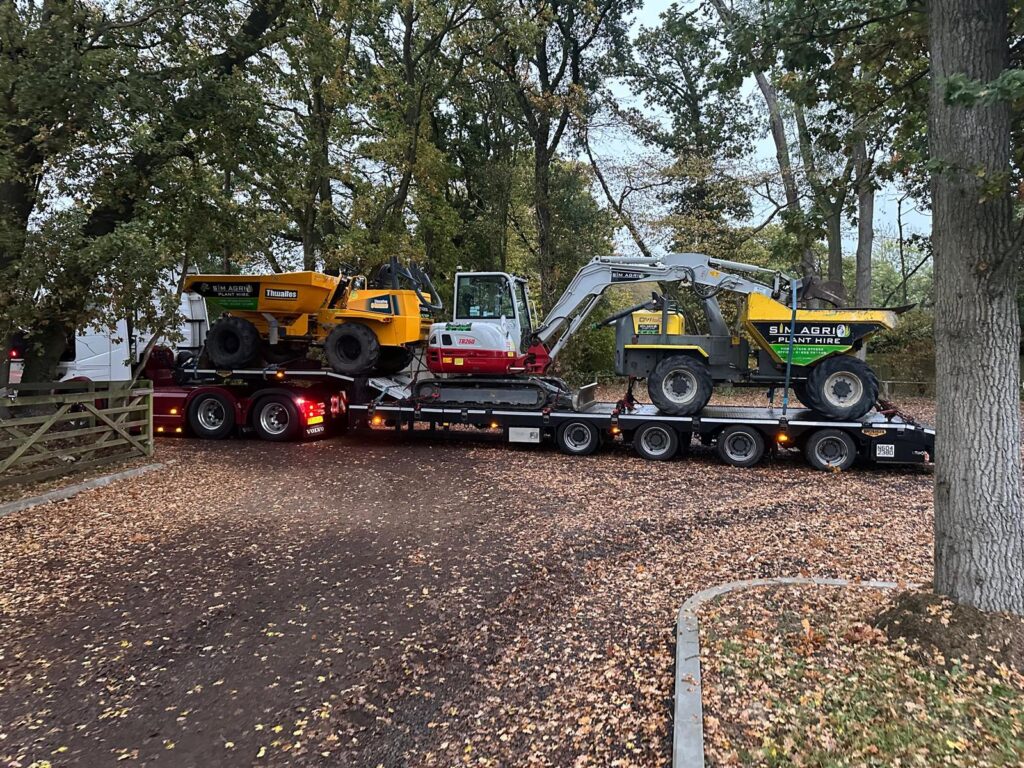 Sims low-loader transporting machines for a construction plant hire account