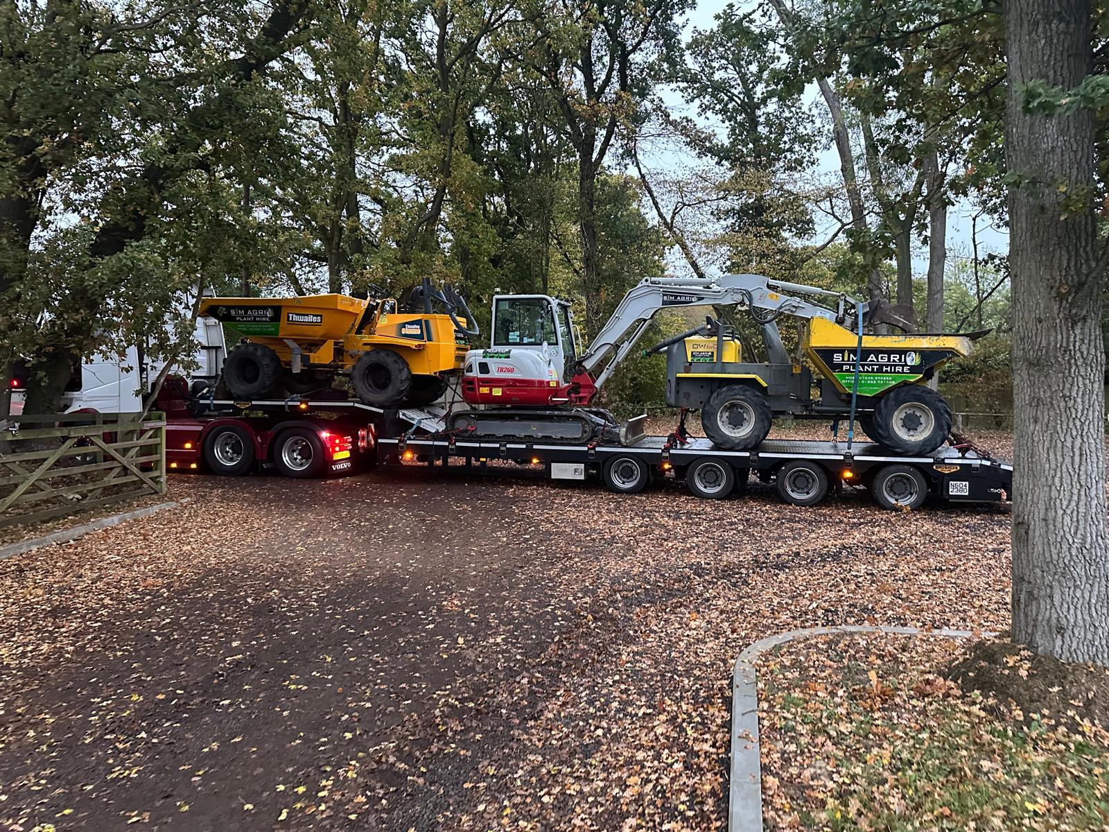 Sims low-loader transporting machines for a construction plant hire account